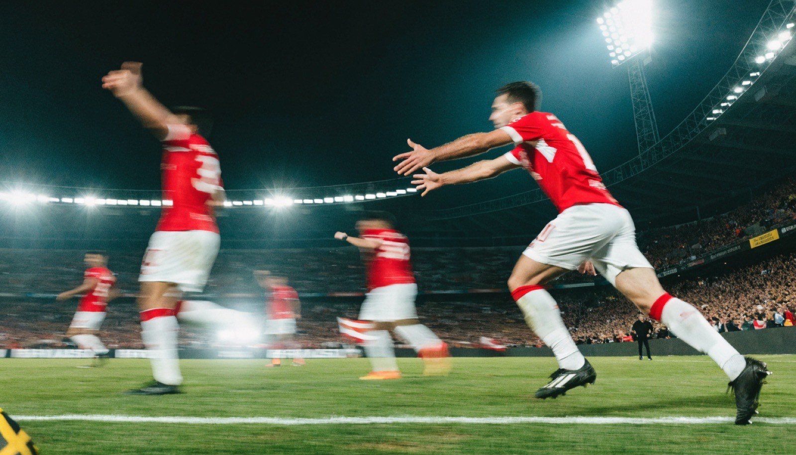 Estádio de futebol lotado sob refletores