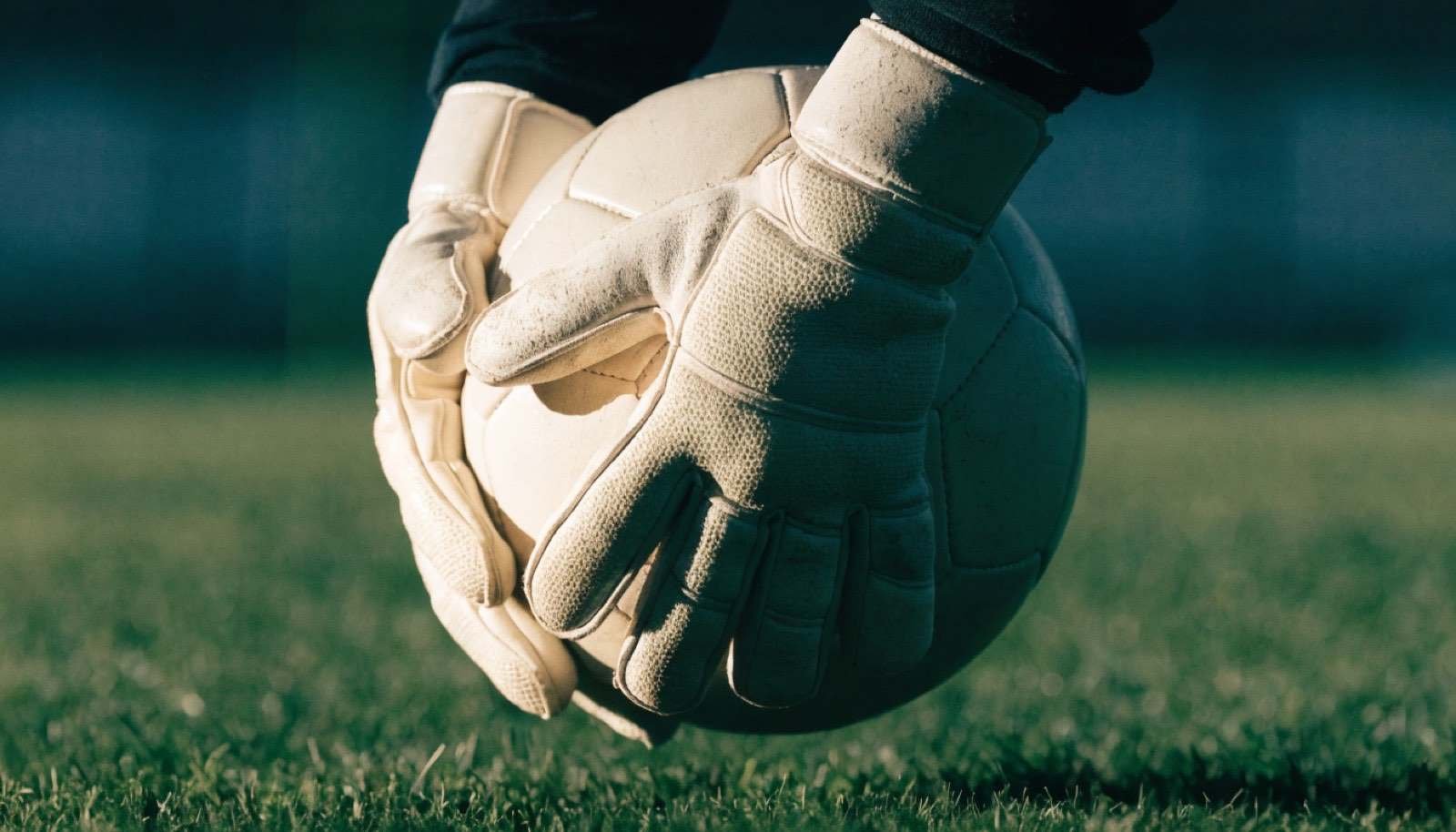 Luvas de goleiro em campo de futebol