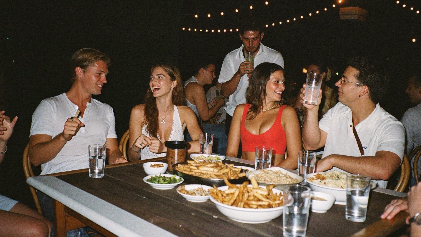 Amigos reunidos em mesa de bar à noite