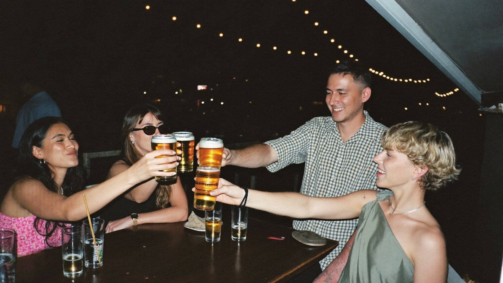 Pessoas brindando com bebidas em bar