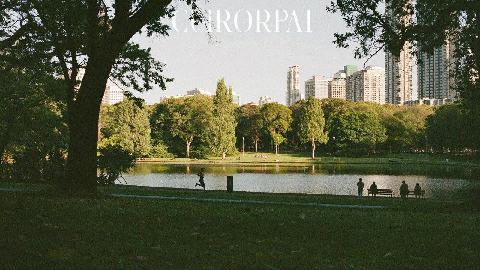 Pessoa correndo em trilha ao redor de lago em parque urbano ao entardecer