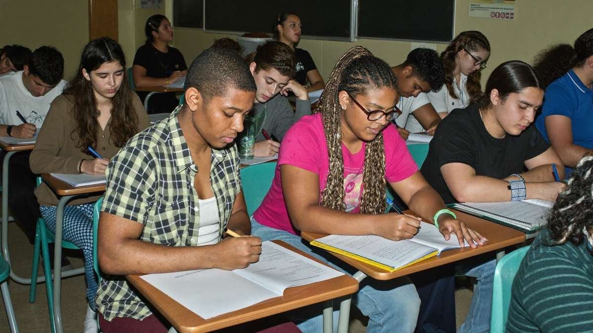 Grupo de estudantes em sala de cursinho tomando notas