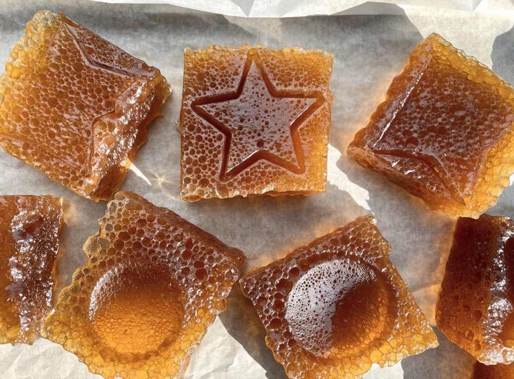 Pedaços de dalgona candy com formatos de estrela e círculo marcados, imagem ilustrativa