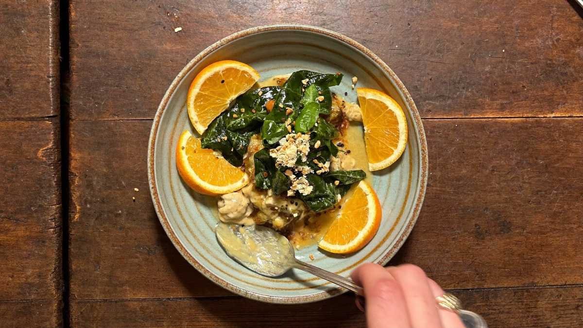 Prato de feijoada tradicional com farofa, couve e laranja