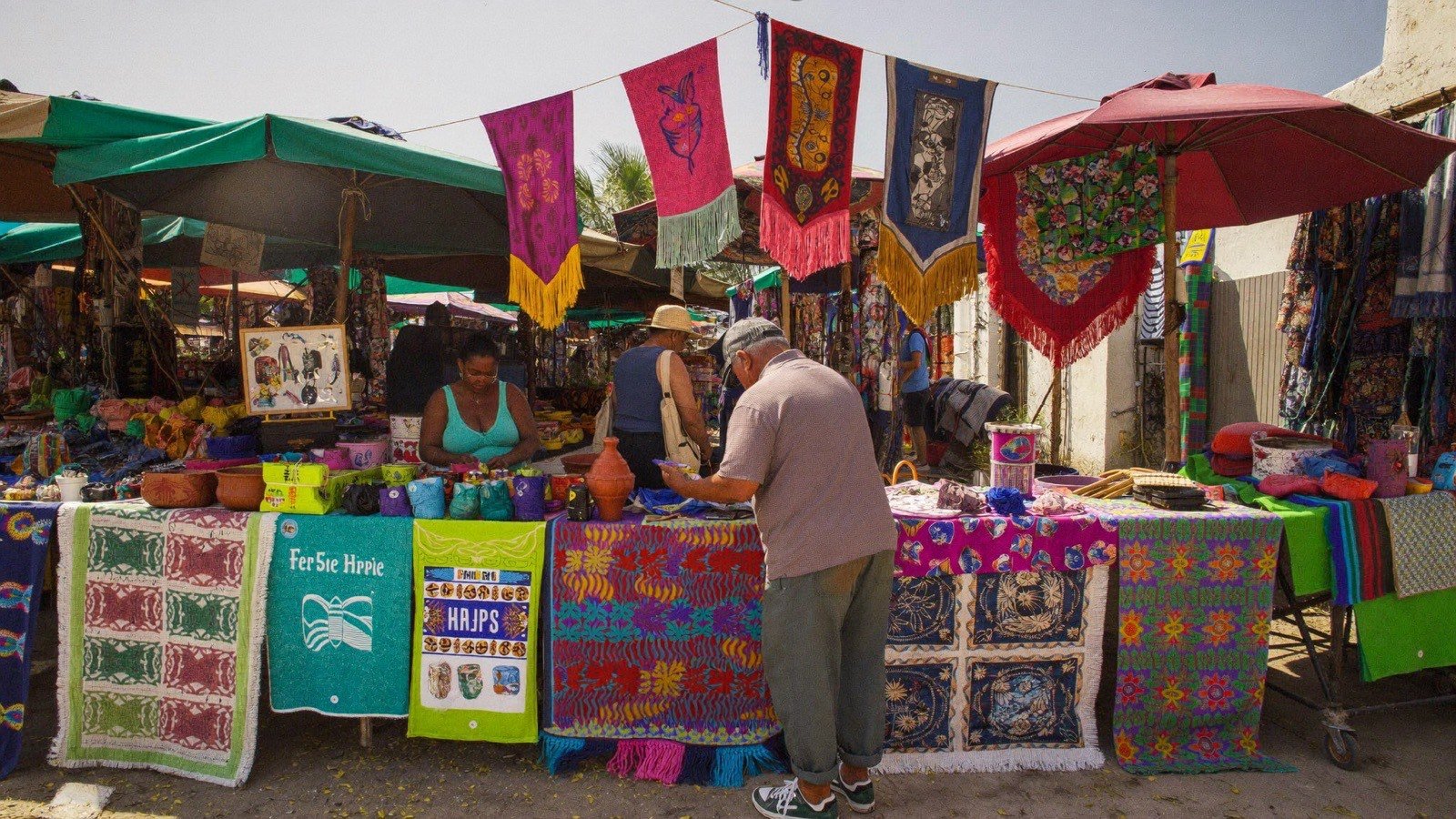 Feira de artesanato ao ar livre com tecidos e cerâmica