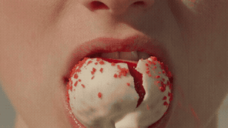 Mordida em morango cravejado mostrando o morango de verdade no centro, envolto pelo recheio de brigadeiro branco