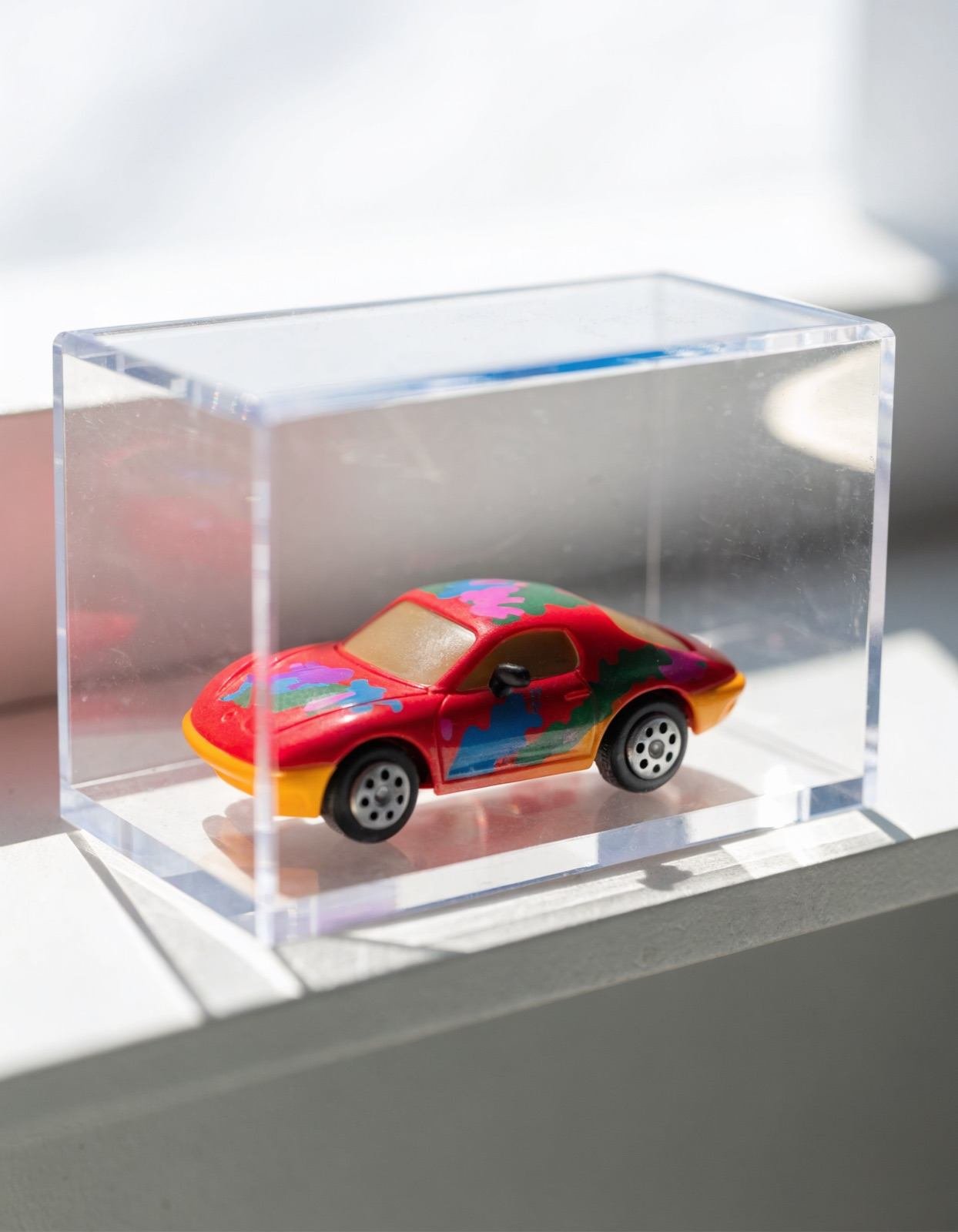 Carrinho de brinquedo colecionável dentro de caixa de acrílico transparente, imagem ilustrativa