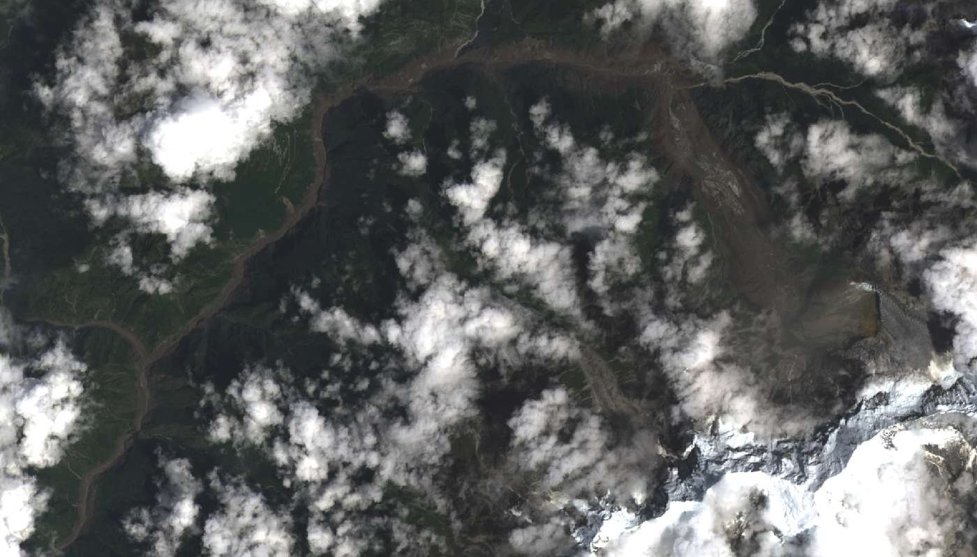 Imagem de satélite Landsat mostra a cicatriz marrom de um deslizamento de lama ao lado de um vale verde nas montanhas do Himalaia, na fronteira entre Nepal e Tibete