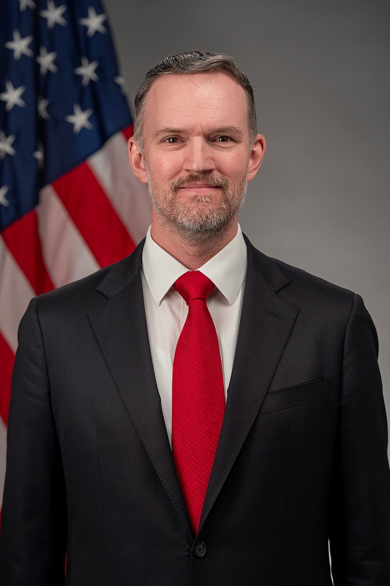 Jamieson Greer, representante comercial dos Estados Unidos, em retrato oficial ao lado da bandeira americana