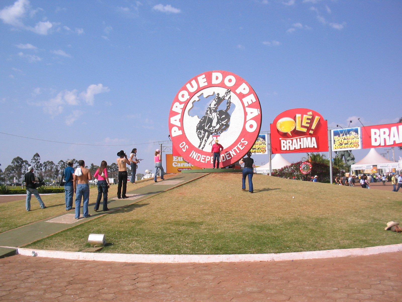 Entrada do Parque do Peão de Barretos, com o monumento "Parque do Peão" e visitantes durante a festa