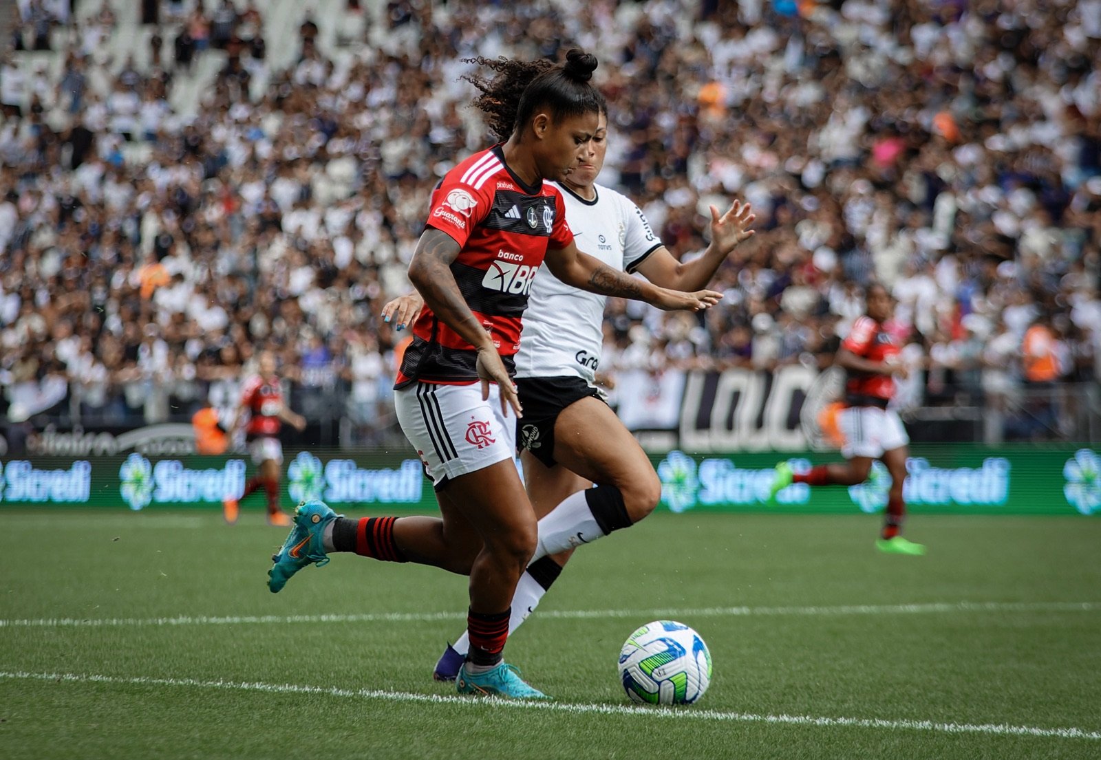 Jogadoras de Corinthians e Flamengo disputam bola durante partida do futebol feminino