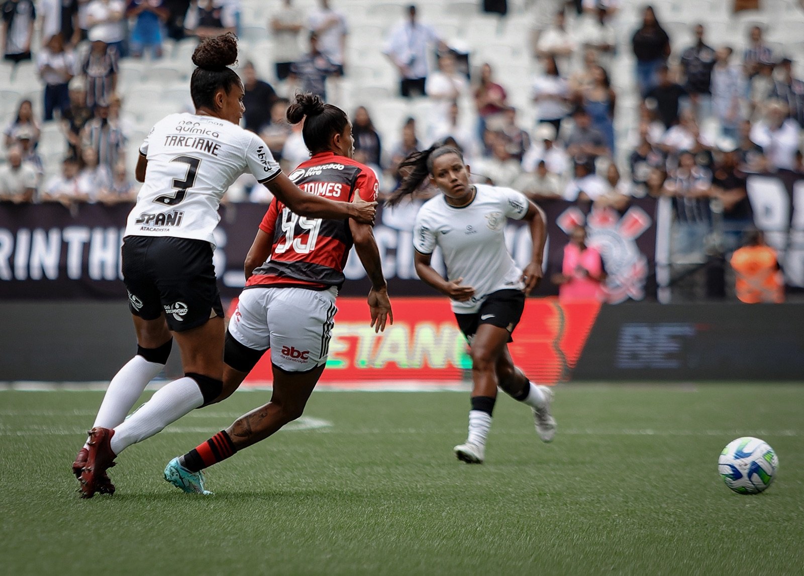 Jogadoras do Corinthians em ação com a camisa branca e preta do clube