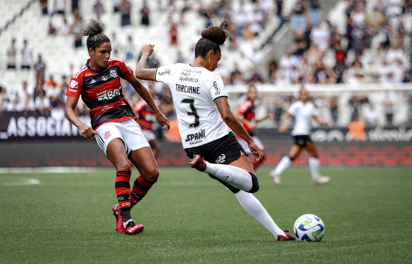 Jogadora do Flamengo disputa bola durante partida com o uniforme vermelho e preto do clube